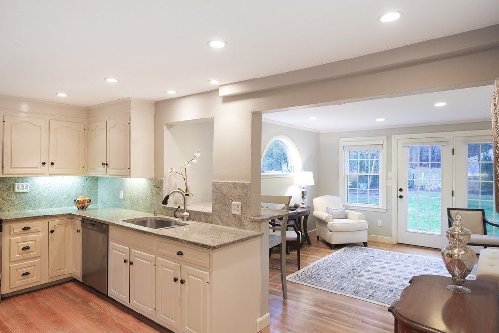 295 Concord Road Wayland, MA 01778 - Photo 11 of 30 a kitchen with granite countertop a sink dishwasher stove and white cabinets with wooden floor