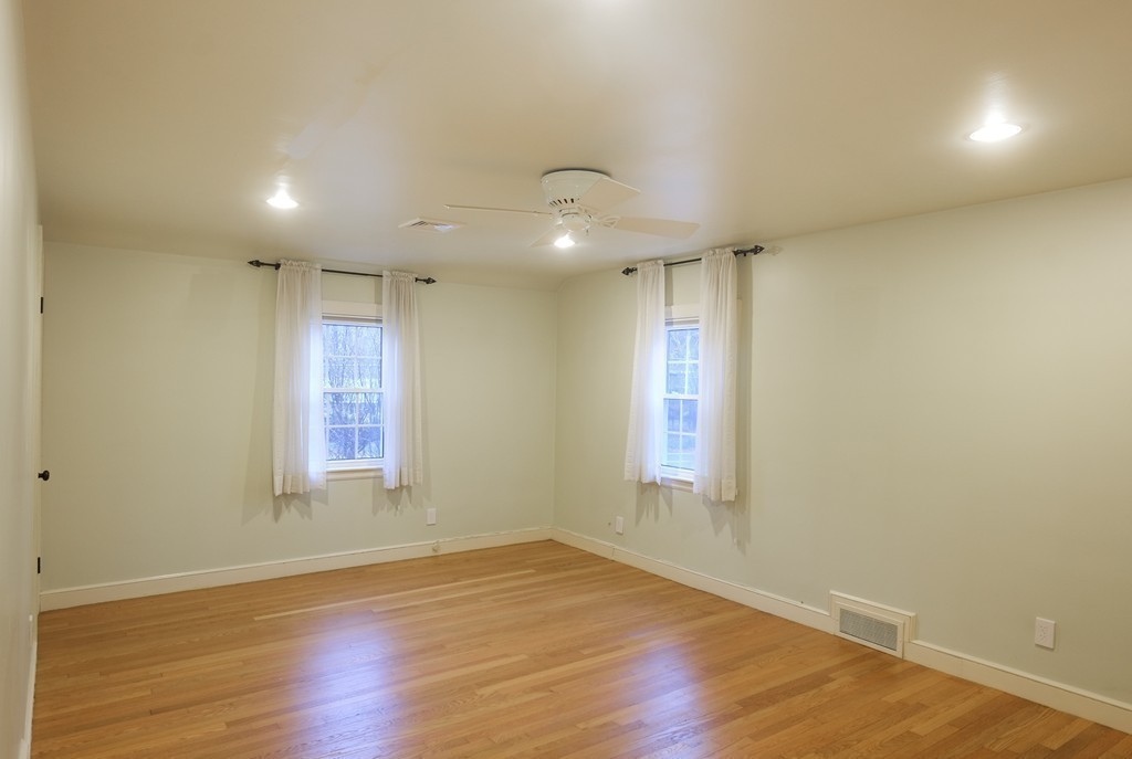 295 Concord Road Wayland, MA 01778 - Photo 19 of 30 an empty room with wooden floor and windows