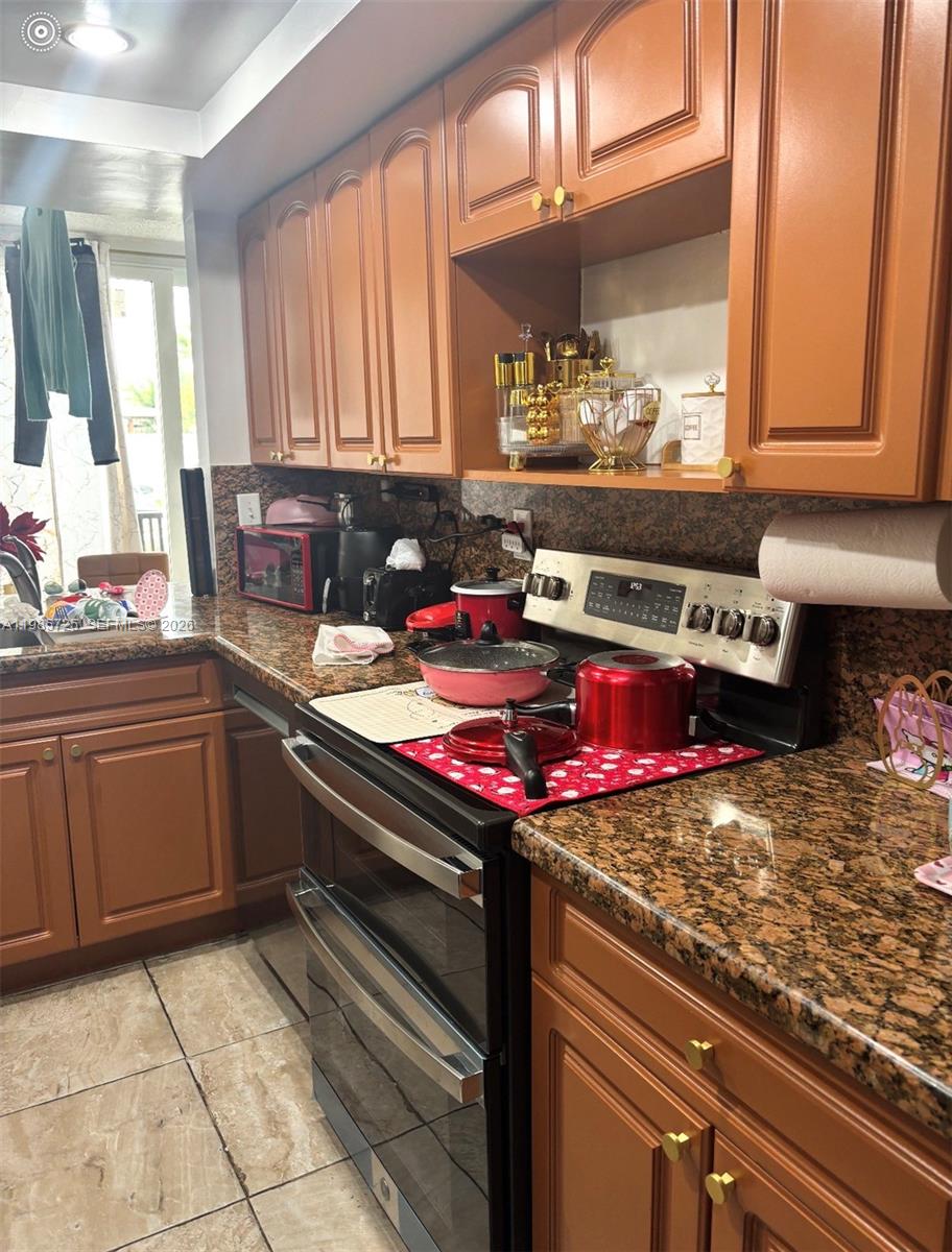 9441 Southwest 4th Street, Unit 111 Miami, FL 33174 - Photo 4 of 6 a kitchen with a stove and cabinets