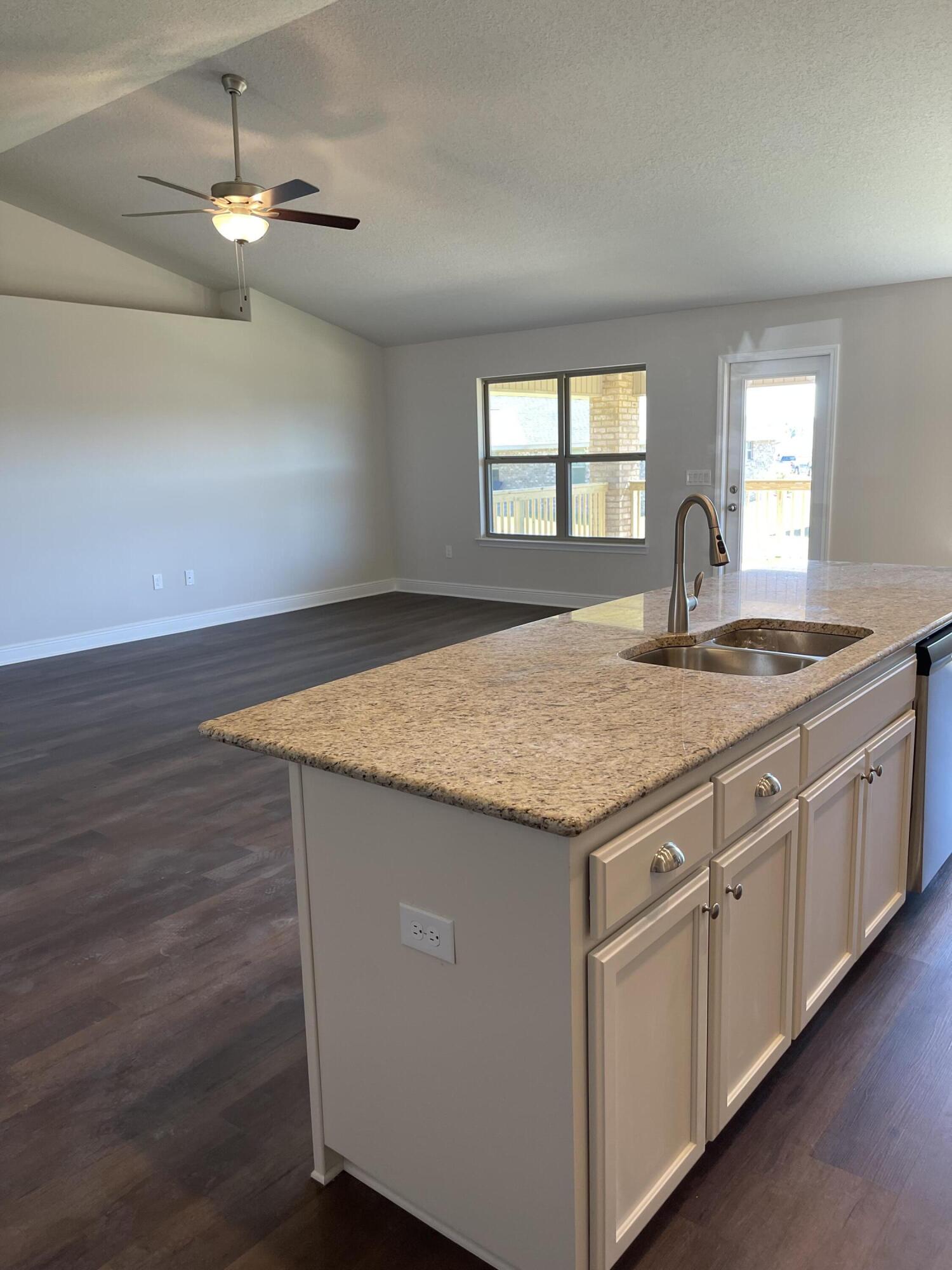 5810 Crestlake Drive Crestview, FL 32536 - Photo 15 of 22 a kitchen with granite countertop kitchen island white cabinets and wooden floor
