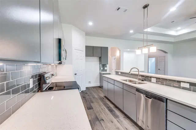 a kitchen with stainless steel appliances a sink stove and cabinets