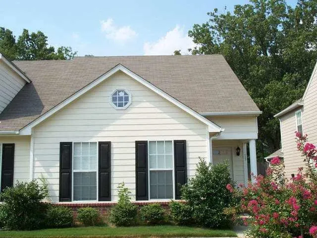 a view of a house with brick walls and flower plants