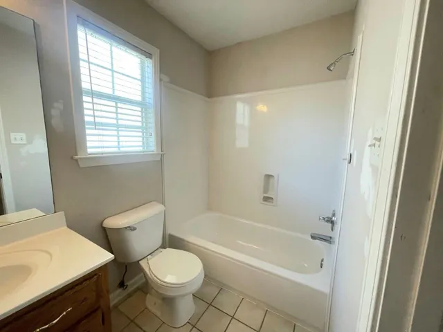 a white toilet sitting next to a bath tub