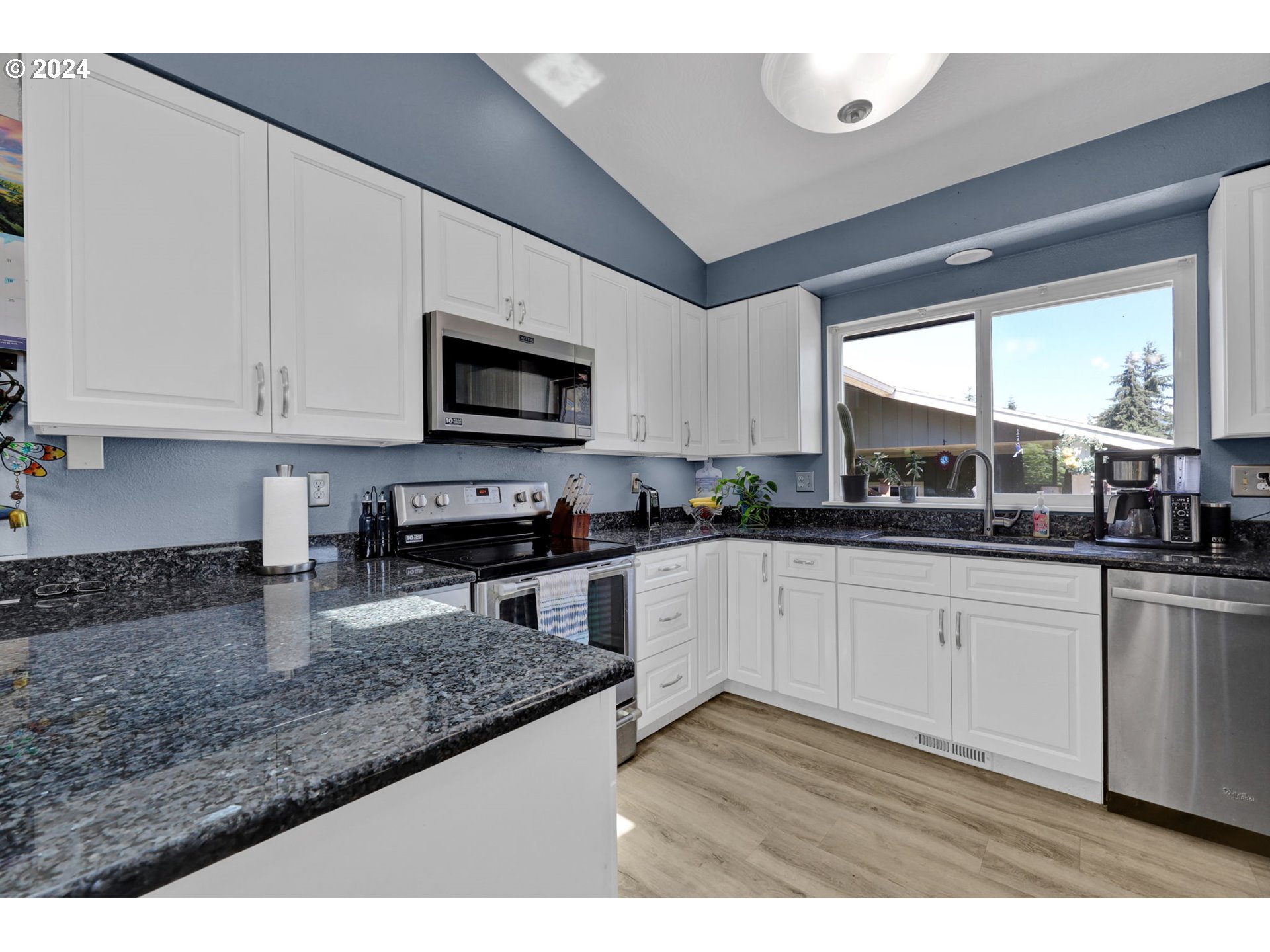 253 South 70th Place Springfield, OR 97478 - Photo 15 of 43 a kitchen with stainless steel appliances granite countertop a stove a sink and a microwave