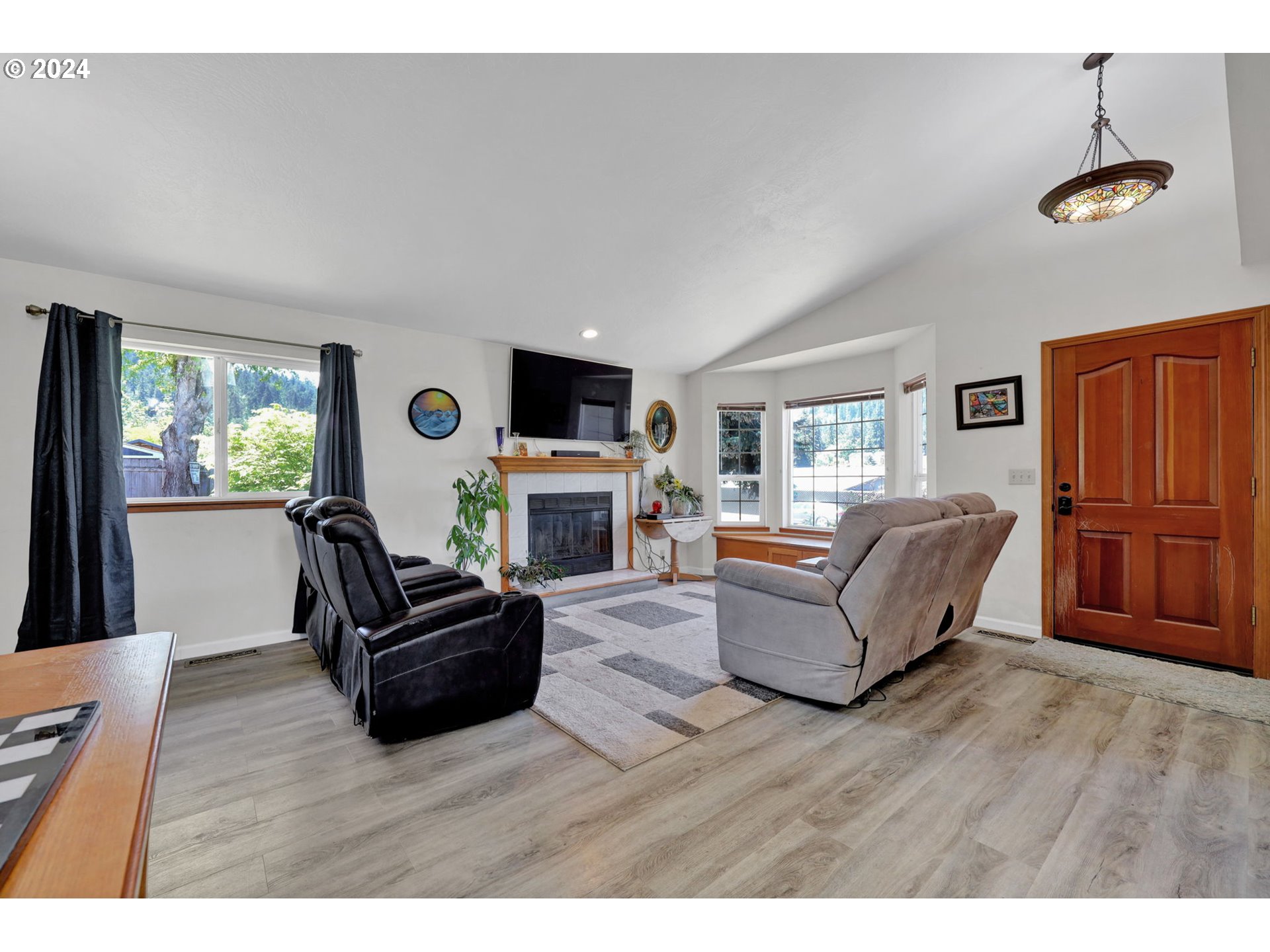 253 South 70th Place Springfield, OR 97478 - Photo 5 of 43 a living room with furniture a fireplace and a flat screen tv