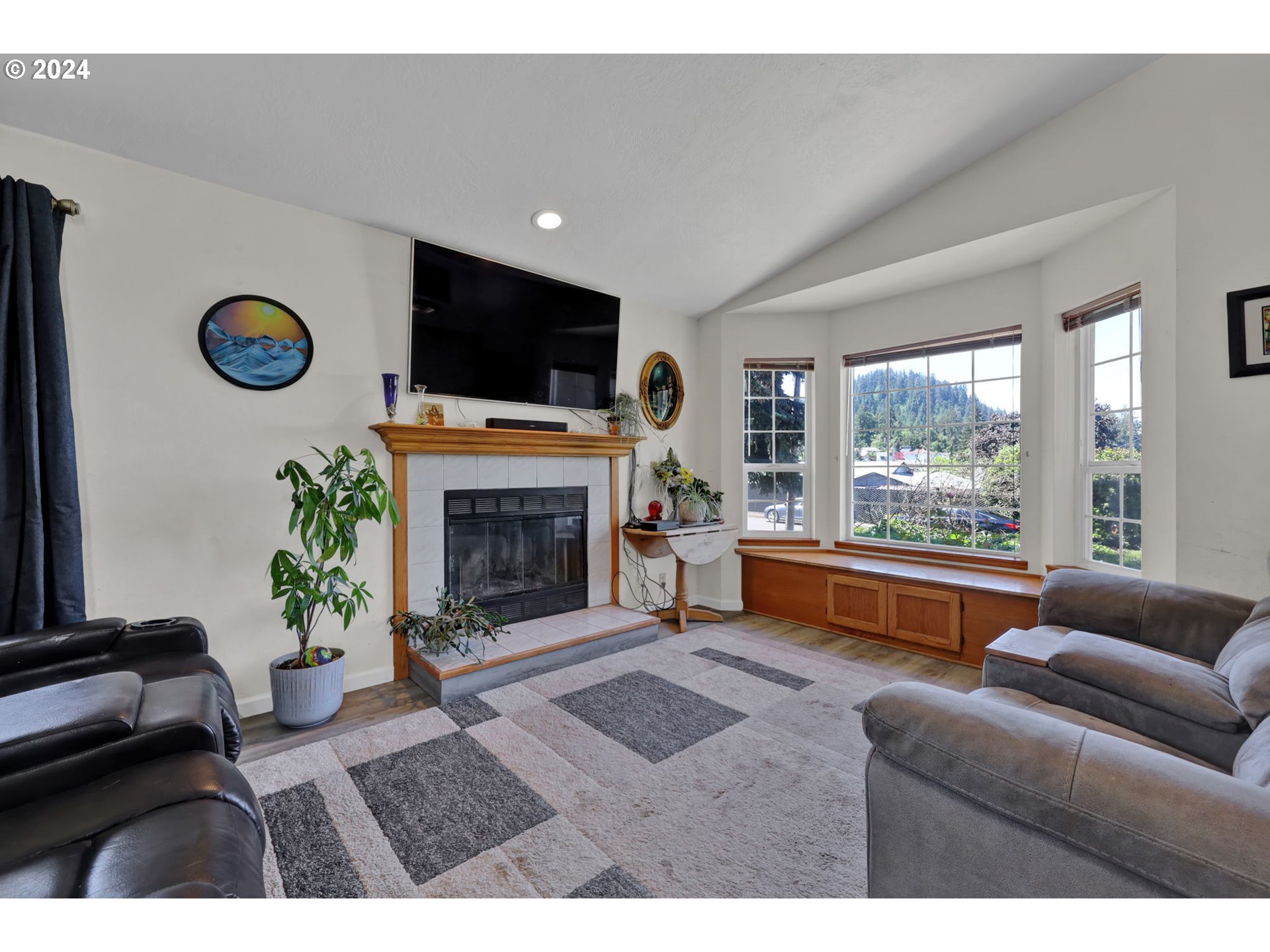 253 South 70th Place Springfield, OR 97478 - Photo 6 of 43 a living room with furniture a flat screen tv and a fireplace