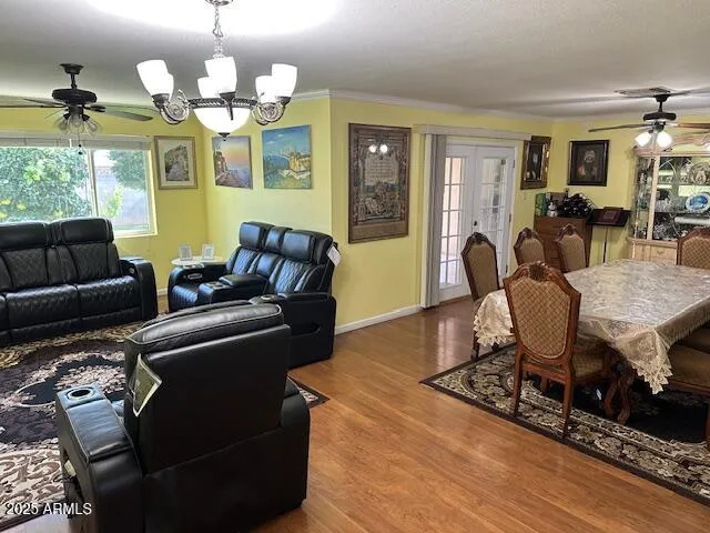 a living room with furniture a chandelier and a dining table