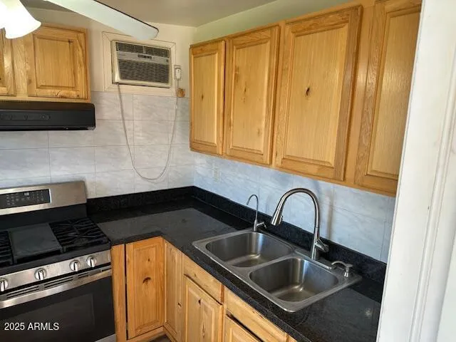 a kitchen with granite countertop a sink and a stove top oven