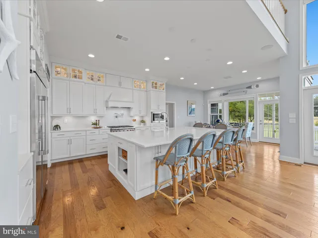 a large living room with stainless steel appliances granite countertop a couch a table and chairs