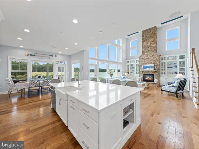 a kitchen with stainless steel appliances granite countertop a stove top oven a refrigerator a sink with a dining table and chairs