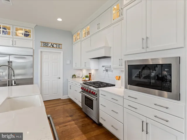a dining room with furniture large windows and wooden floor