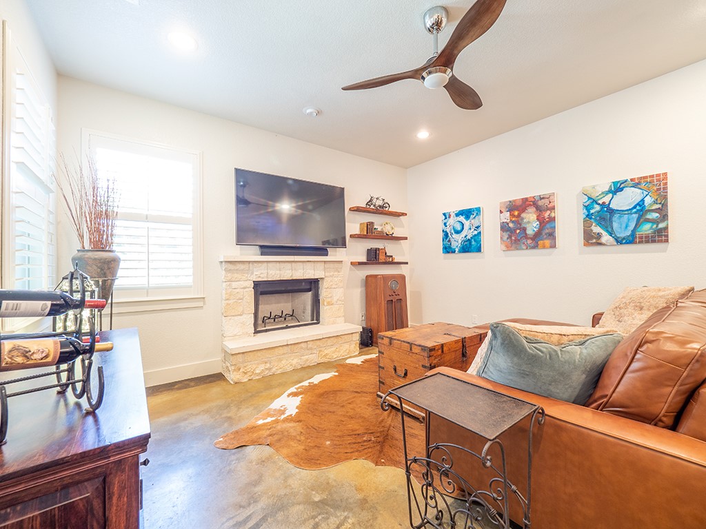 55 Tournament Way, Unit B The Hills, TX 78738 - Photo 11 of 23 a living room with furniture a flat screen tv and a fireplace