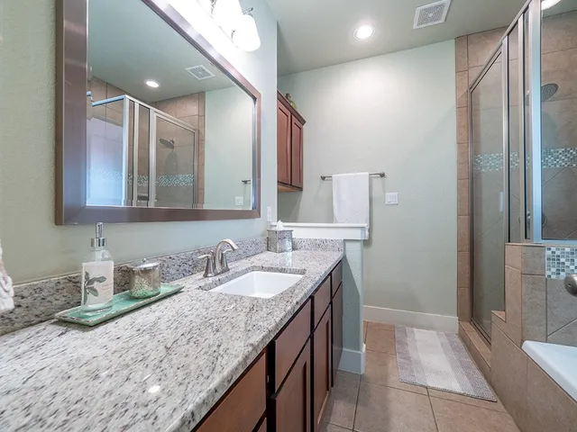 a bathroom with a granite countertop sink and a mirror