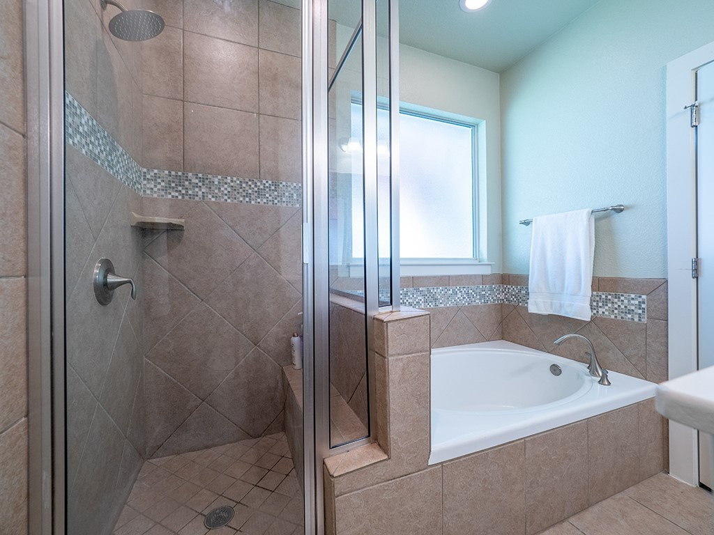 55 Tournament Way, Unit B The Hills, TX 78738 - Photo 16 of 23 Bathroom featuring a garden tub, a shower stall, and tile patterned flooring