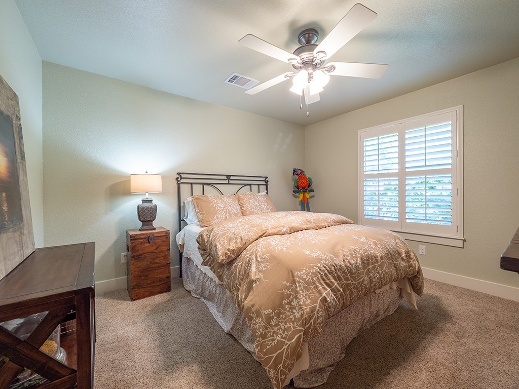 55 Tournament Way, Unit B The Hills, TX 78738 - Photo 18 of 23 a spacious bedroom with a bed and a chandelier