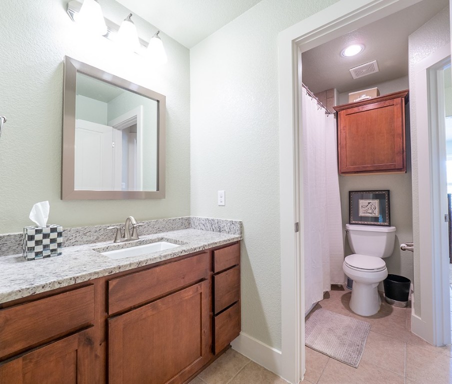 55 Tournament Way, Unit B The Hills, TX 78738 - Photo 21 of 23 a bathroom with a toilet sink and mirror