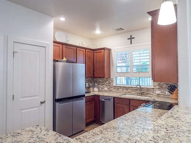 a large kitchen with a large counter top sink and stainless steel appliances