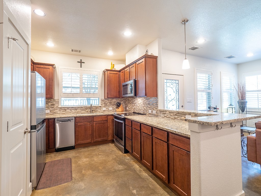 55 Tournament Way, Unit B The Hills, TX 78738 - Photo 6 of 23 a large kitchen with a large counter top sink and stainless steel appliances