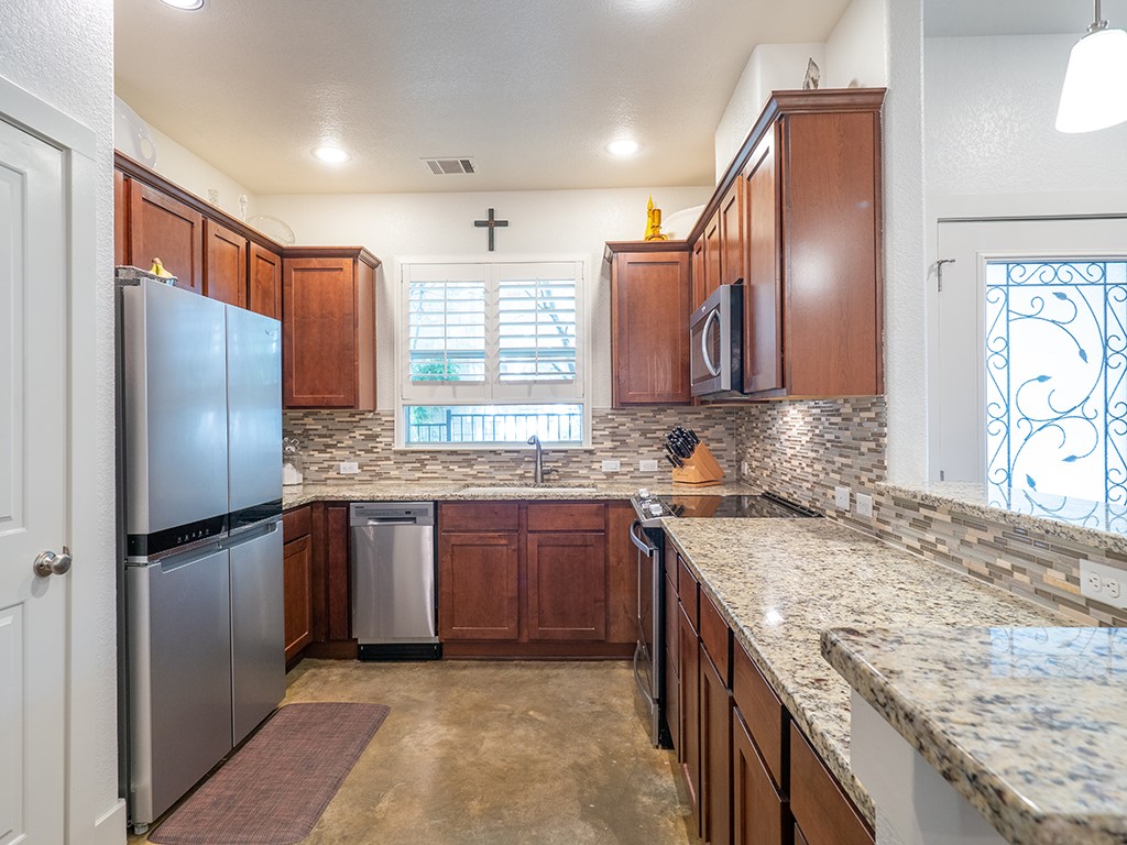 55 Tournament Way, Unit B The Hills, TX 78738 - Photo 7 of 23 a kitchen with stainless steel appliances granite countertop a sink stove and refrigerator