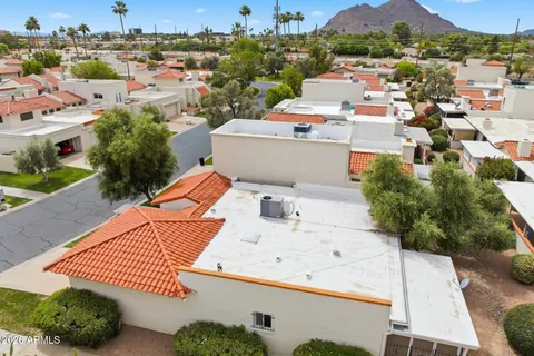 an aerial view of a house with a yard basket ball court and a city view