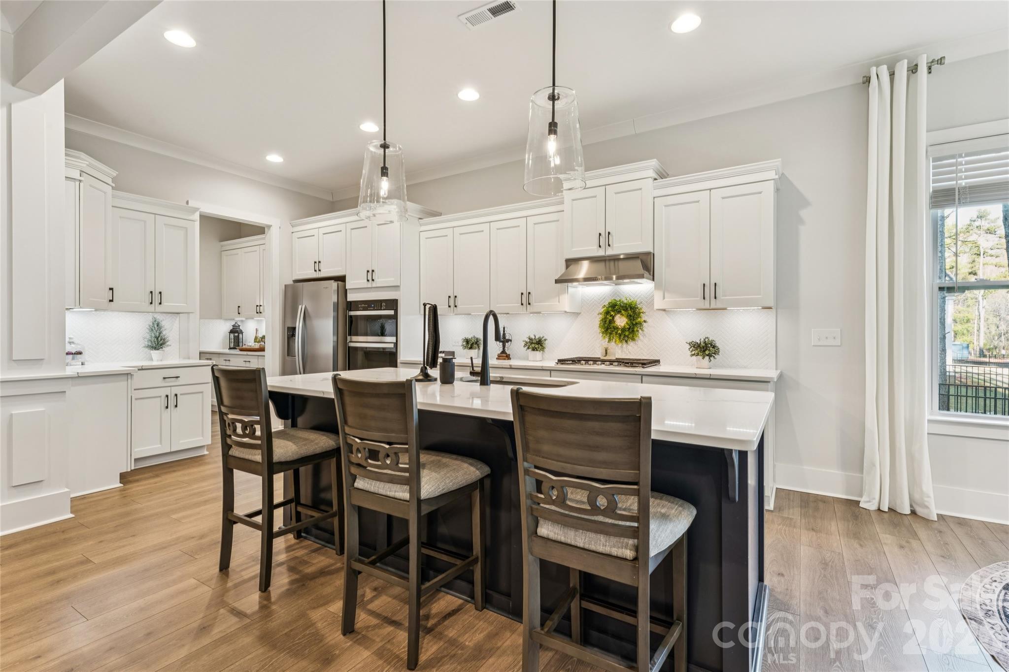 7822 Russell Road Indian Trail, NC 28079 - Photo 13 of 48 a kitchen with kitchen island granite countertop a table and chairs in it
