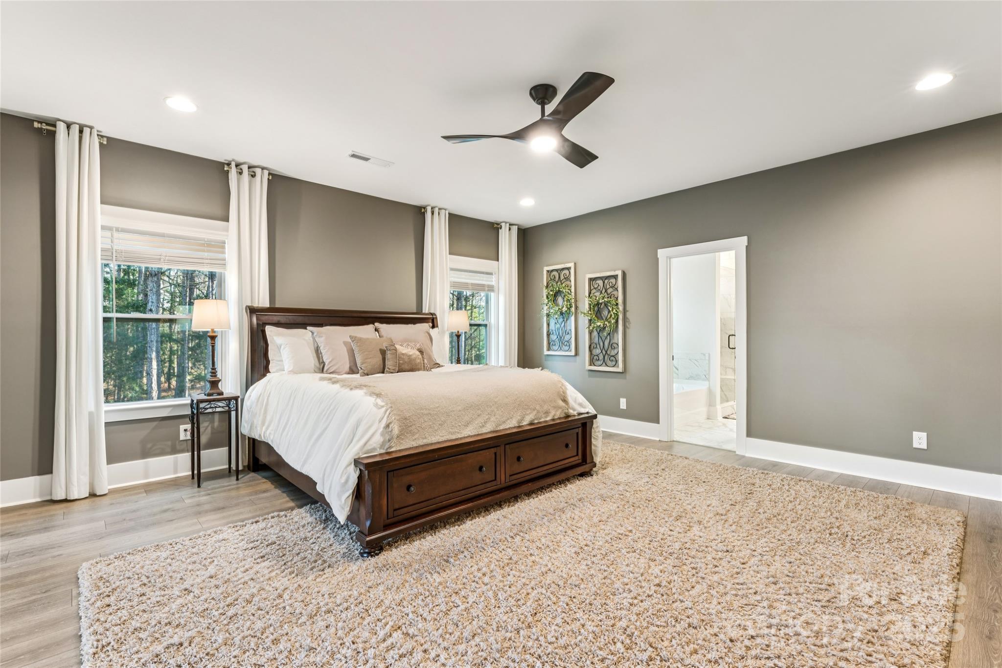 7822 Russell Road Indian Trail, NC 28079 - Photo 29 of 48 a spacious bedroom with a large bed and a large window