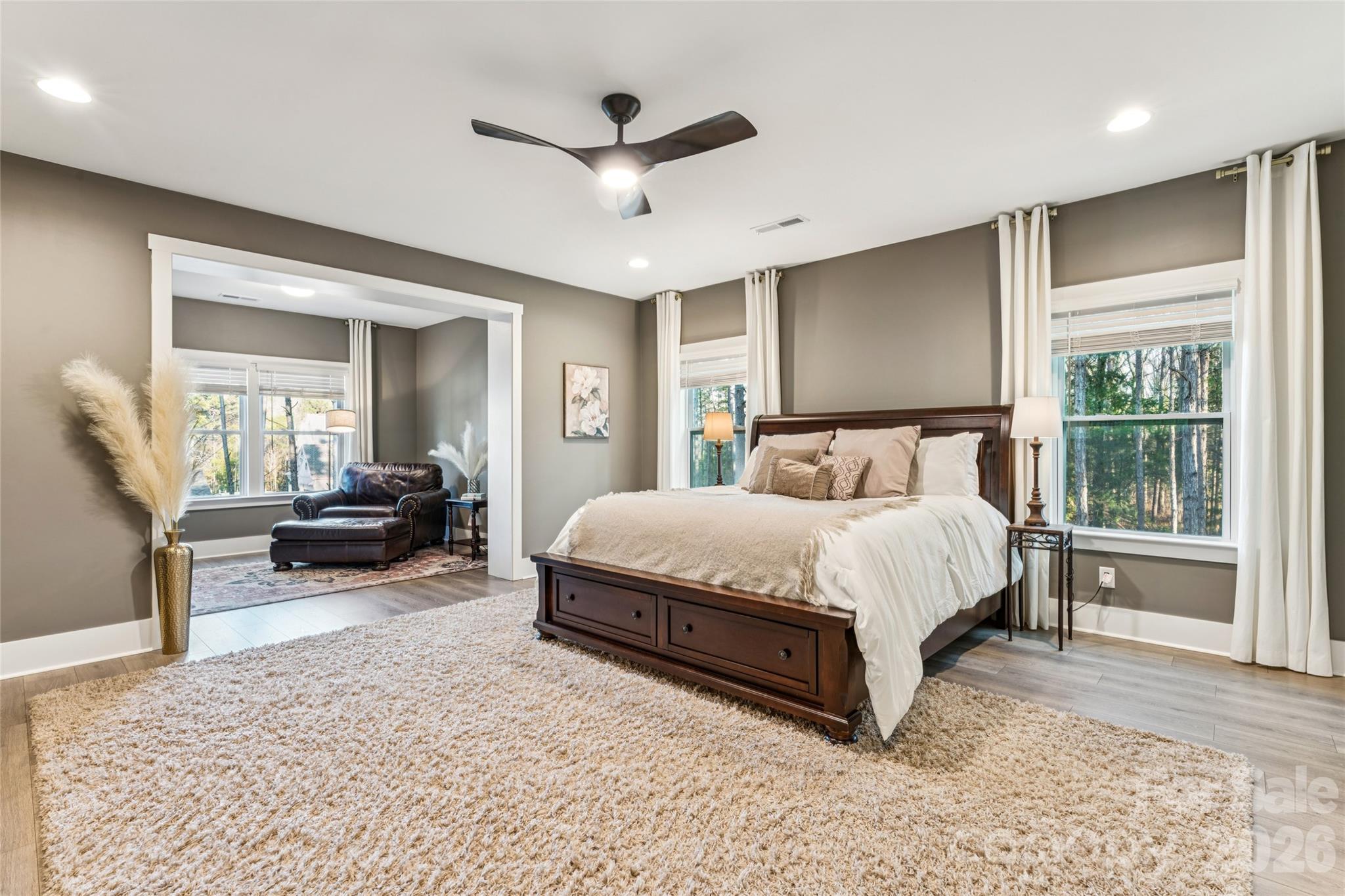 7822 Russell Road Indian Trail, NC 28079 - Photo 31 of 48 a spacious bedroom with a bed a couch and a large window