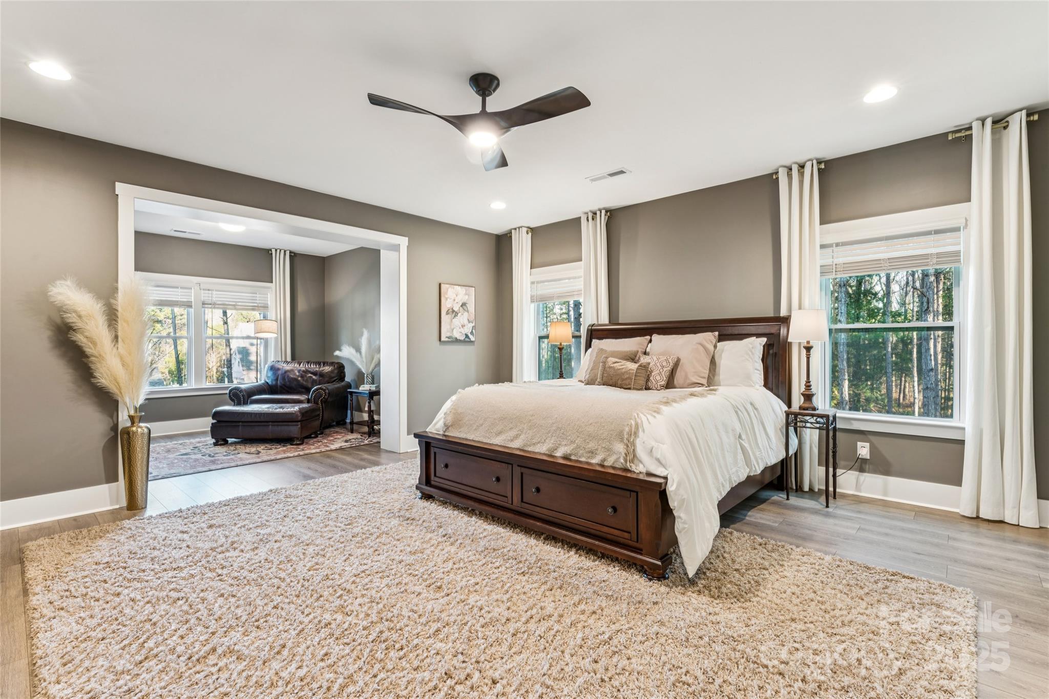 7822 Russell Road Indian Trail, NC 28079 - Photo 31 of 48 a spacious bedroom with a bed a couch and a large window