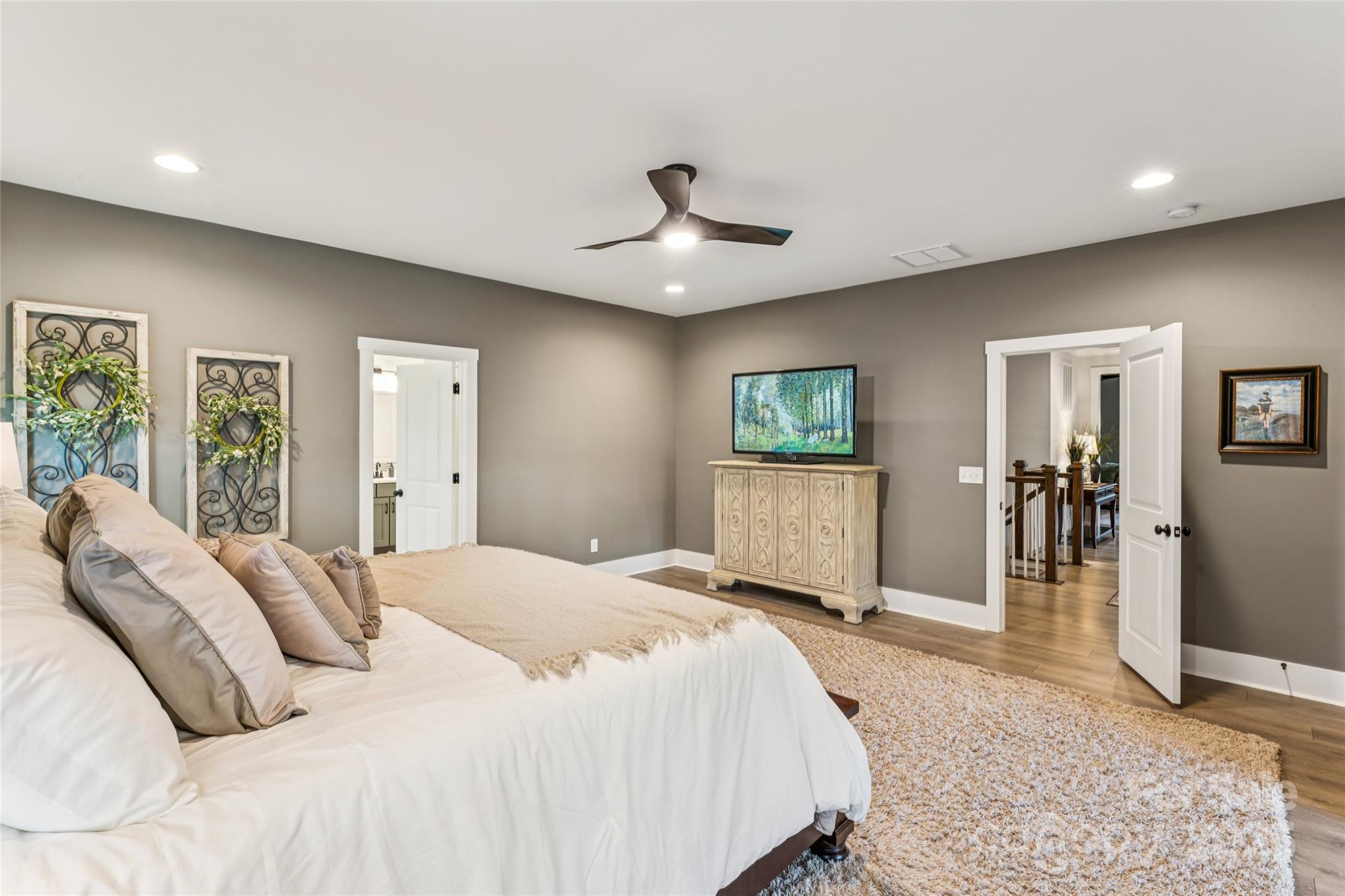7822 Russell Road Indian Trail, NC 28079 - Photo 33 of 48 a spacious bedroom with a large bed a chandelier and closet