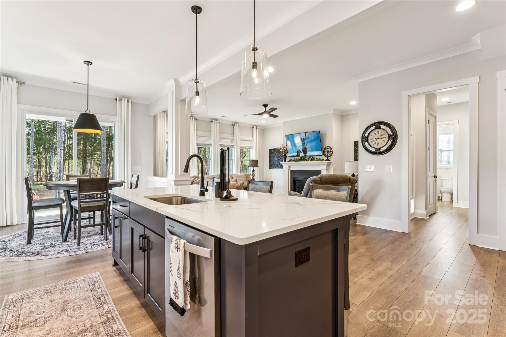 7822 Russell Road Indian Trail, NC 28079 - Photo 10 of 48 a open kitchen with stainless steel appliances granite countertop a kitchen island a stove a sink a dining table and chairs with wooden floor