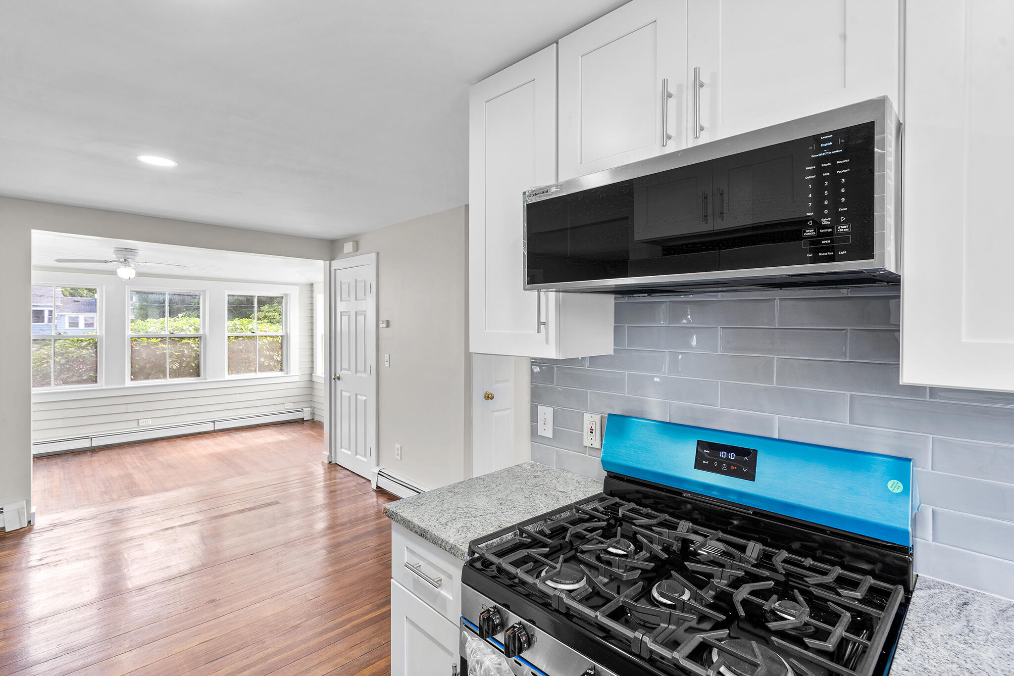 93 Sea Street Hyannis, MA 02601 - Photo 12 of 30 a kitchen with stainless steel appliances kitchen island granite countertop a stove and a microwave