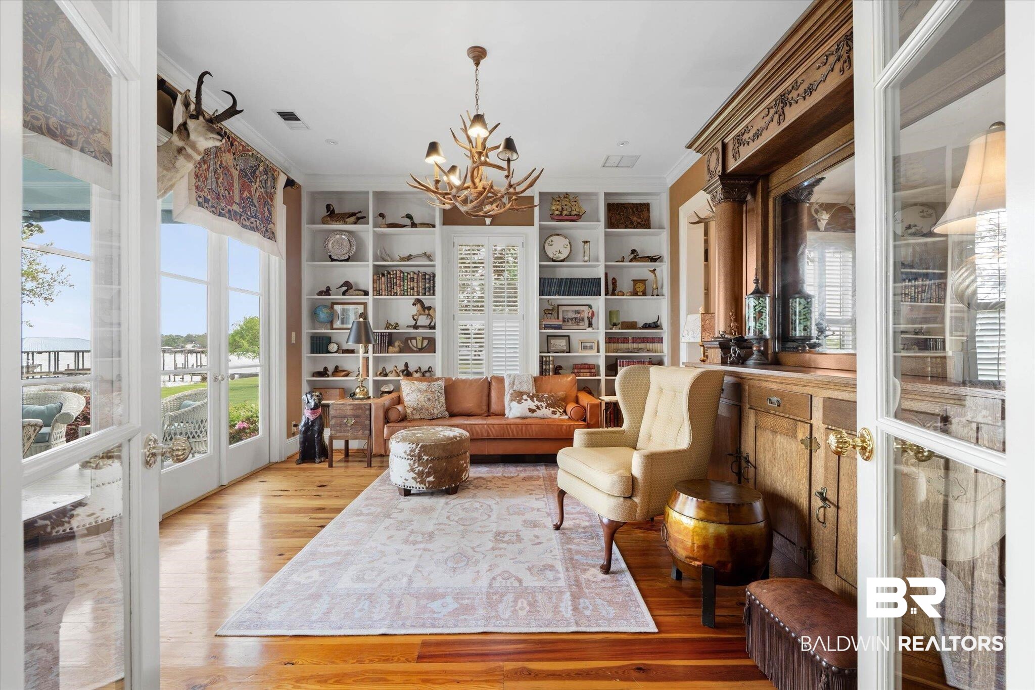 3500 Higgins Road Mobile, AL 36619 - Photo 16 of 54 Living area with hanging lights, crown molding, light wood-type flooring, plenty of natural light, and built in features