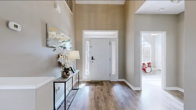a view of a hallway with wooden floor and a bathroom
