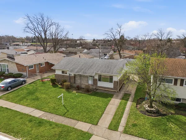 a aerial view of a house with a yard table and chairs