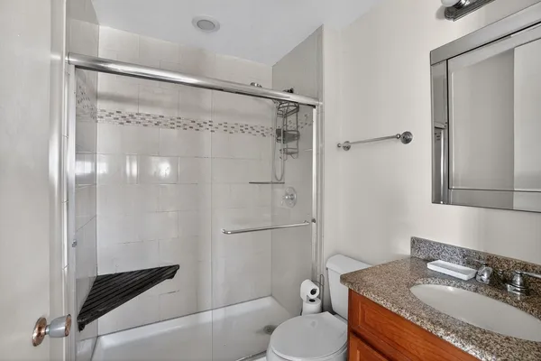 a bathroom with a granite countertop sink toilet and shower