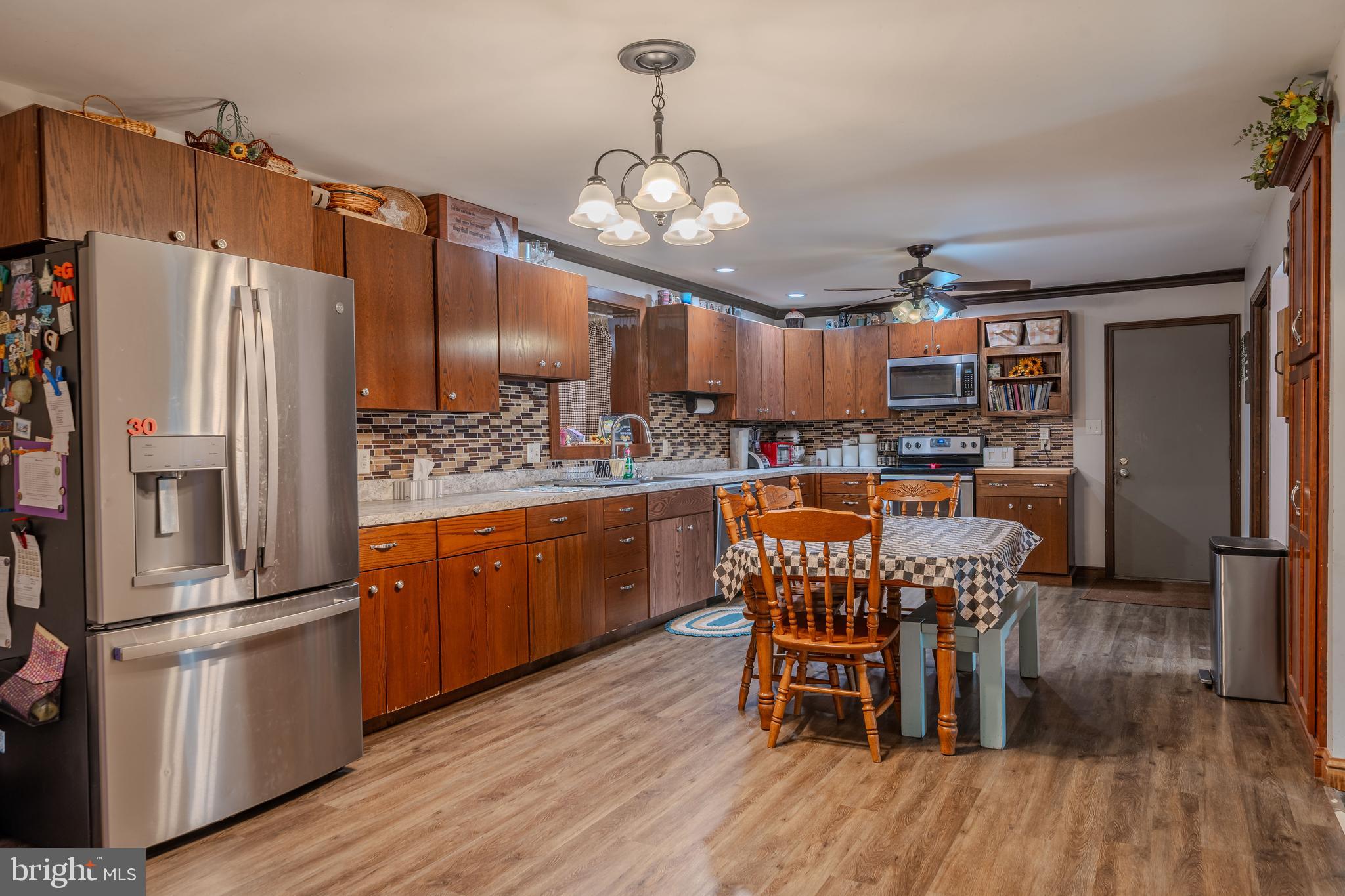 338 Culp Road Sunbury, PA 17801 - Photo 18 of 43 a kitchen with stainless steel appliances kitchen island granite countertop a refrigerator a stove a sink and dishwasher with wooden floor