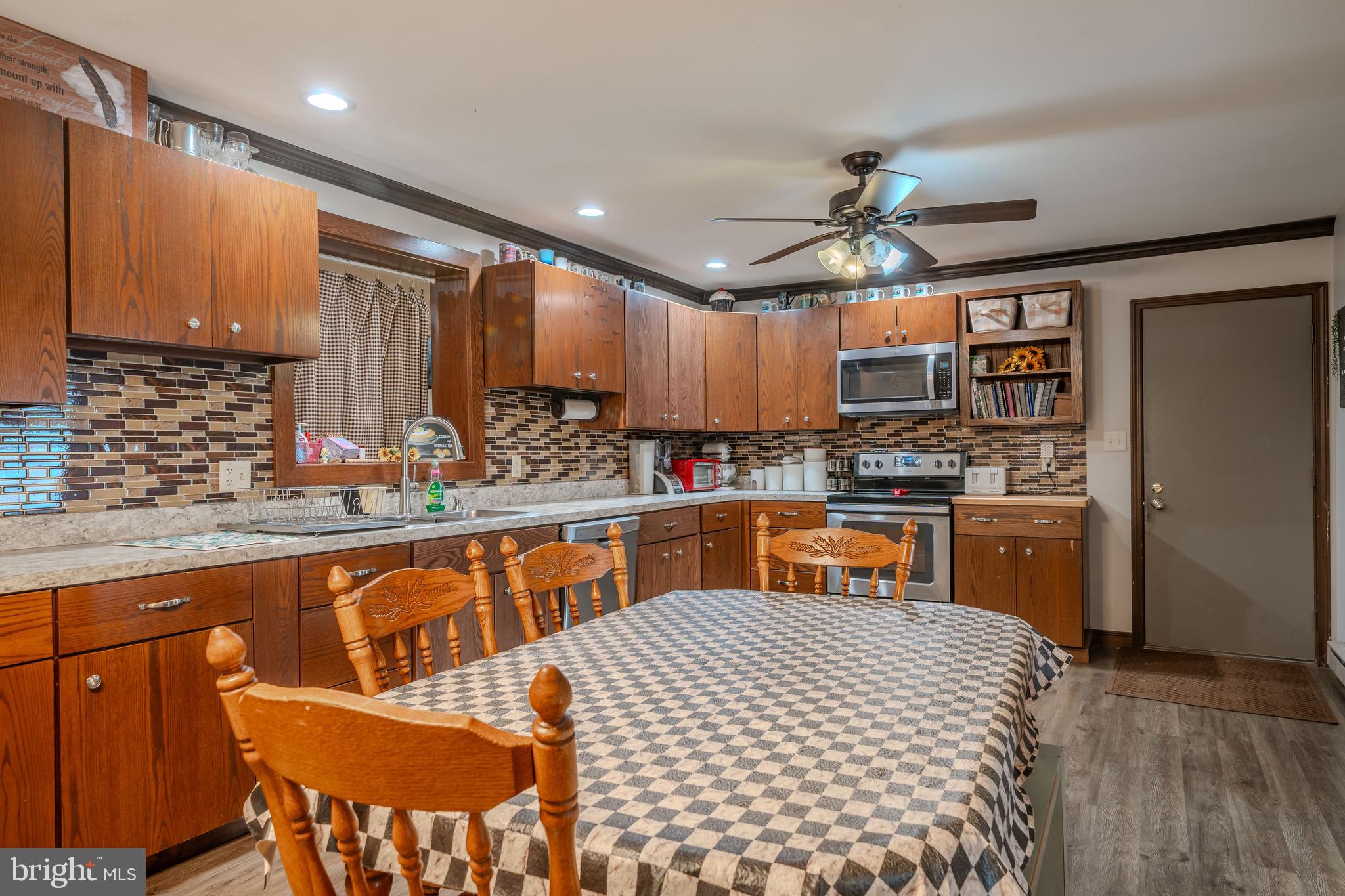 338 Culp Road Sunbury, PA 17801 - Photo 19 of 43 a kitchen with stainless steel appliances kitchen island granite countertop a refrigerator a sink dishwasher a dining table and chairs with wooden floor