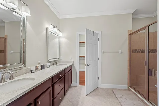 a bathroom with double vanity and a mirror
