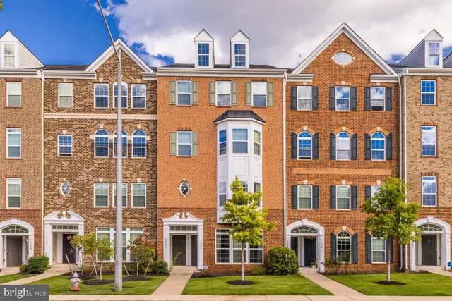 a front view of a residential apartment building with a yard