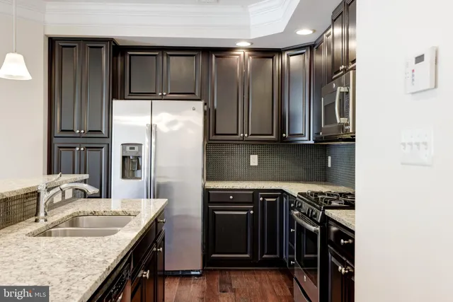 a kitchen with stainless steel appliances granite countertop a sink stove and refrigerator