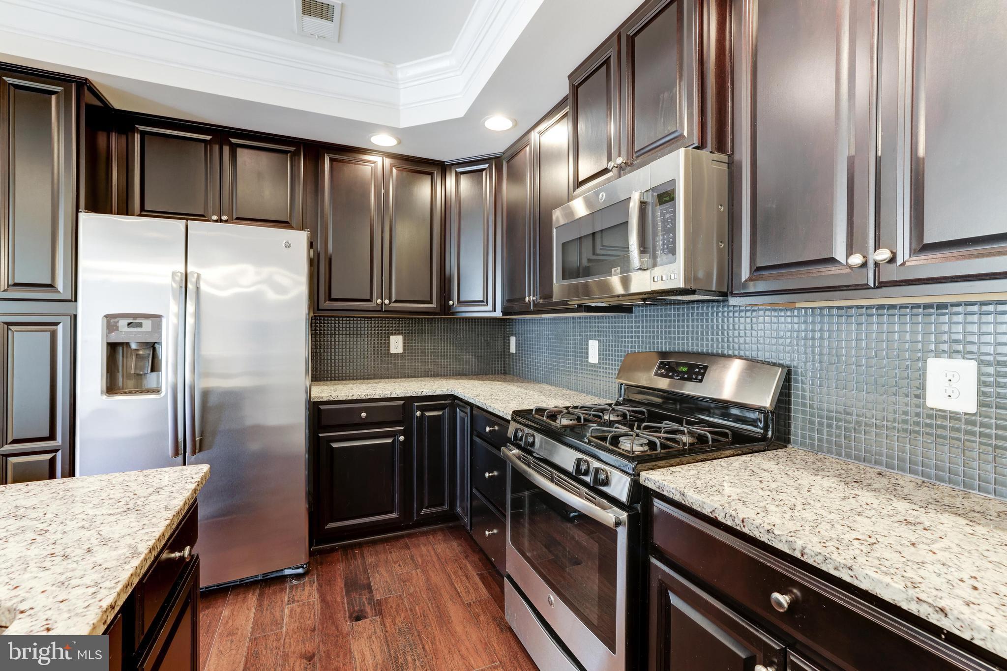 13643 Air And Parkway, Unit MUSEUM 9L Herndon, VA 20171 - Photo 18 of 45 a kitchen with stainless steel appliances granite countertop a stove a sink dishwasher and refrigerator