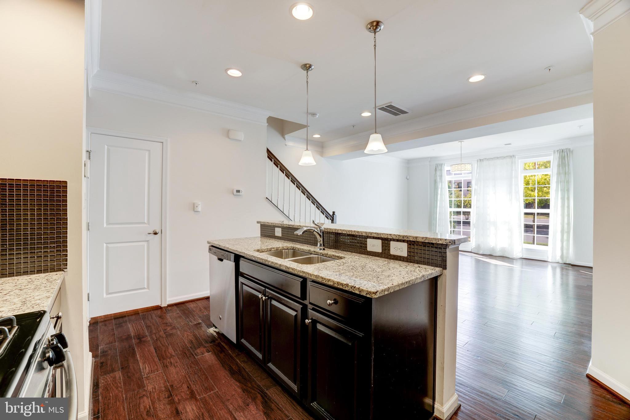 13643 Air And Parkway, Unit MUSEUM 9L Herndon, VA 20171 - Photo 20 of 45 a kitchen with a stove a sink and wooden floor