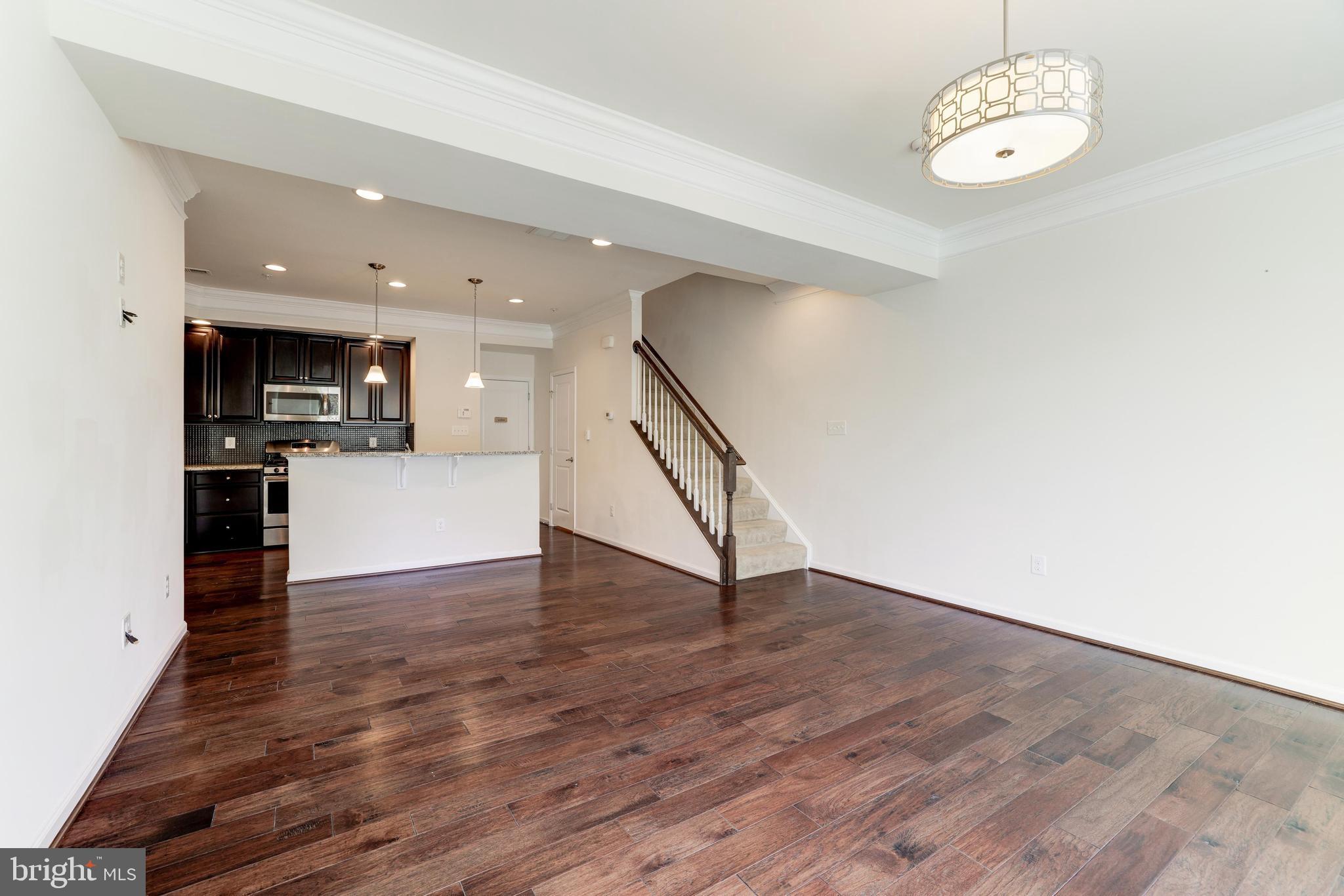 13643 Air And Parkway, Unit MUSEUM 9L Herndon, VA 20171 - Photo 4 of 45 a view of a kitchen with a sink wooden floor and a large window