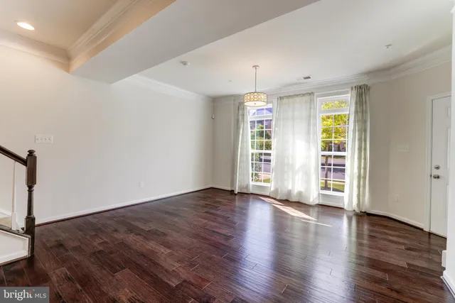 an empty room with wooden floor and a window