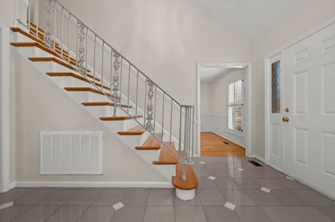 an empty room with wooden floor and ceiling fan
