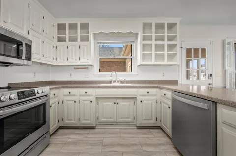 a bathroom with a sink a mirror a vanity and shower