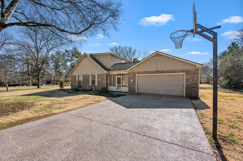 a front view of a house with a yard covered with snow