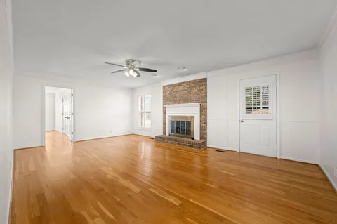 a view of a white house with a large tree in front of it
