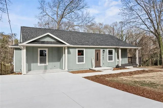 a front view of a house with a garden and trees