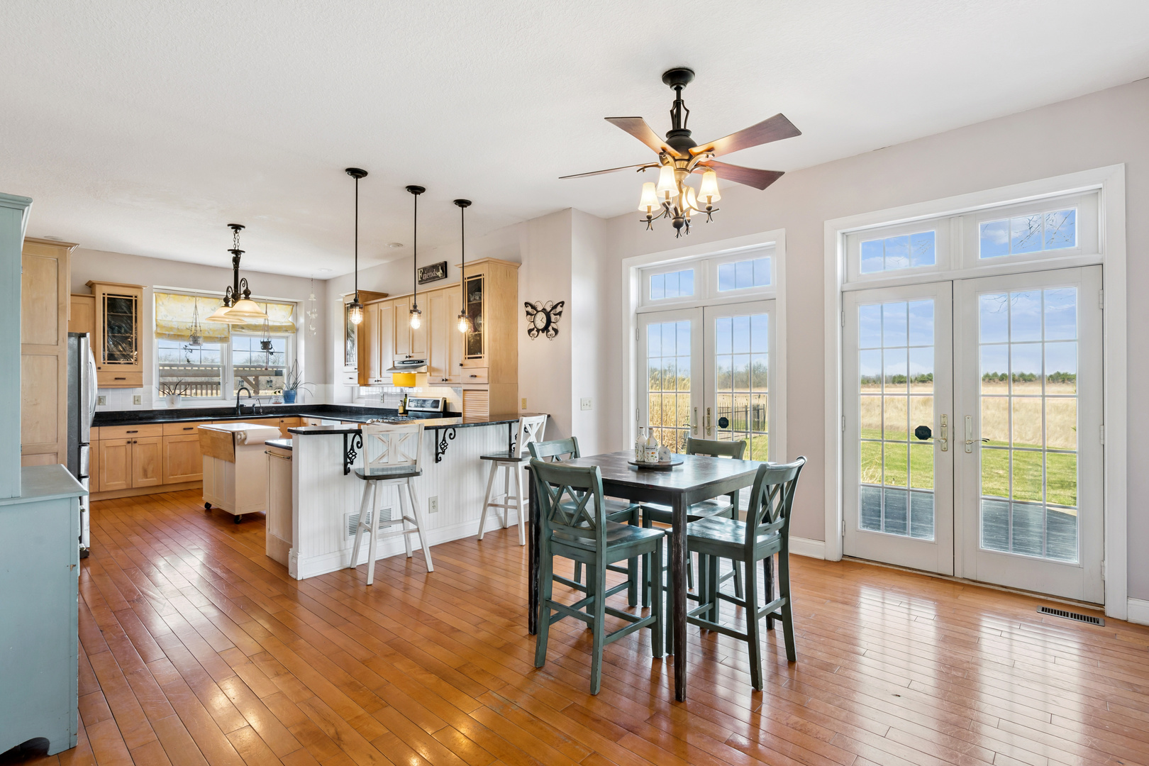 3203 148th Avenue Milan, IL 61264 - Photo 3 of 65 a dining hall with stainless steel appliances kitchen island granite countertop furniture and wooden floor